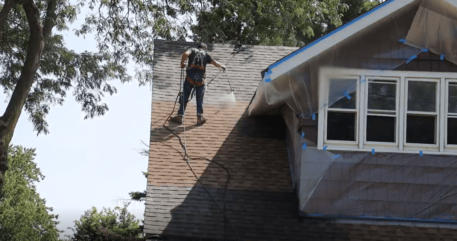 Employee applying cericade to roof of a house
